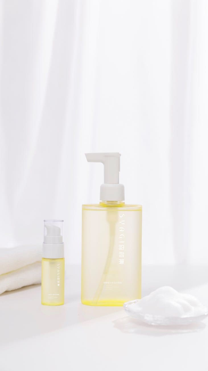 Simple and elegant skincare products in yellow bottles on a white background.