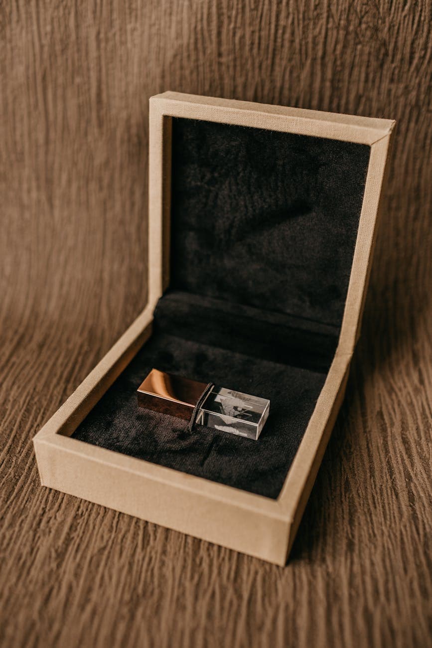 Stylish USB flash drive displayed in an open wooden box with a textured brown background.