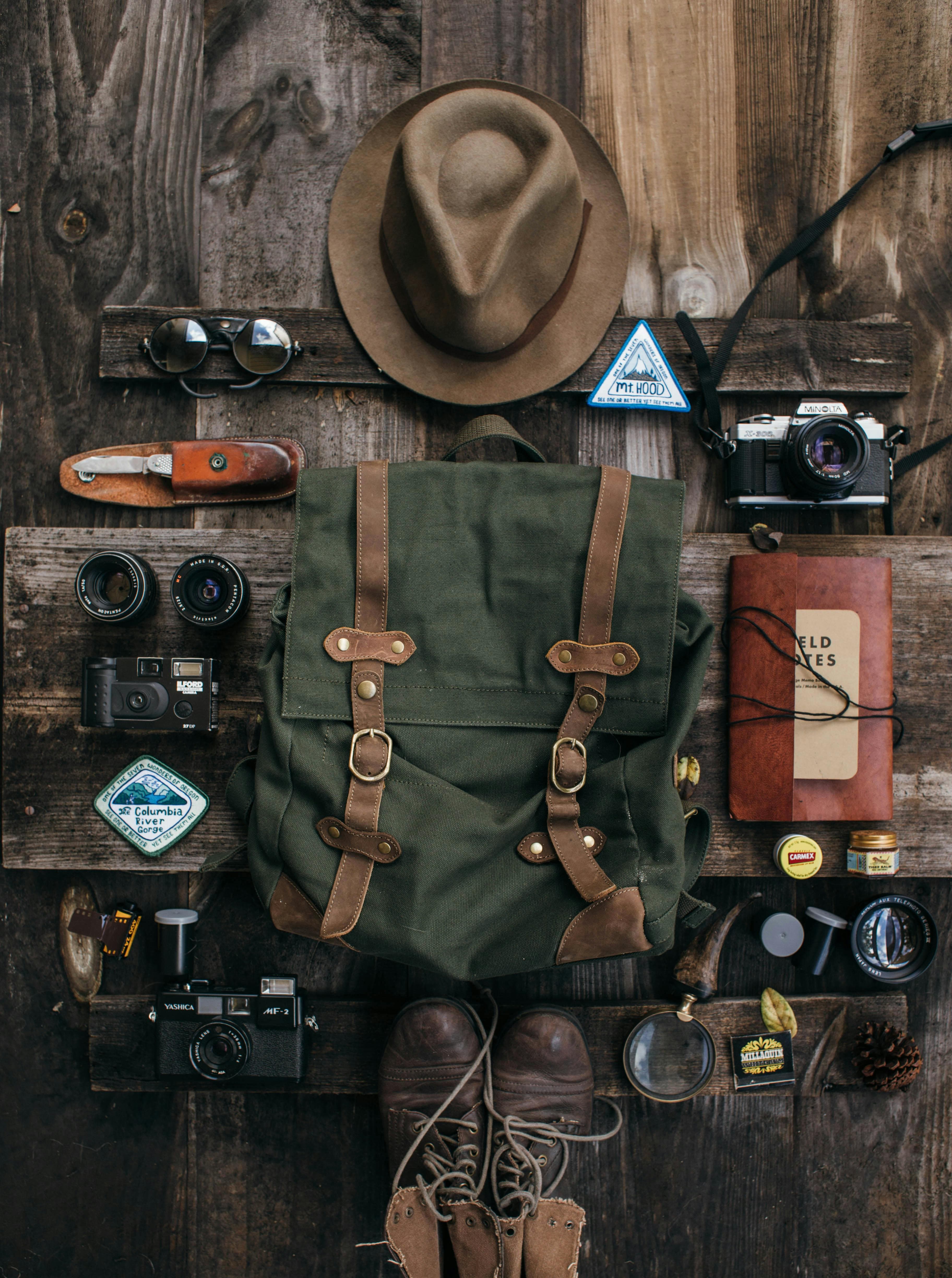 Top view of travel essentials laid out on wooden planks for an adventure-ready setup.