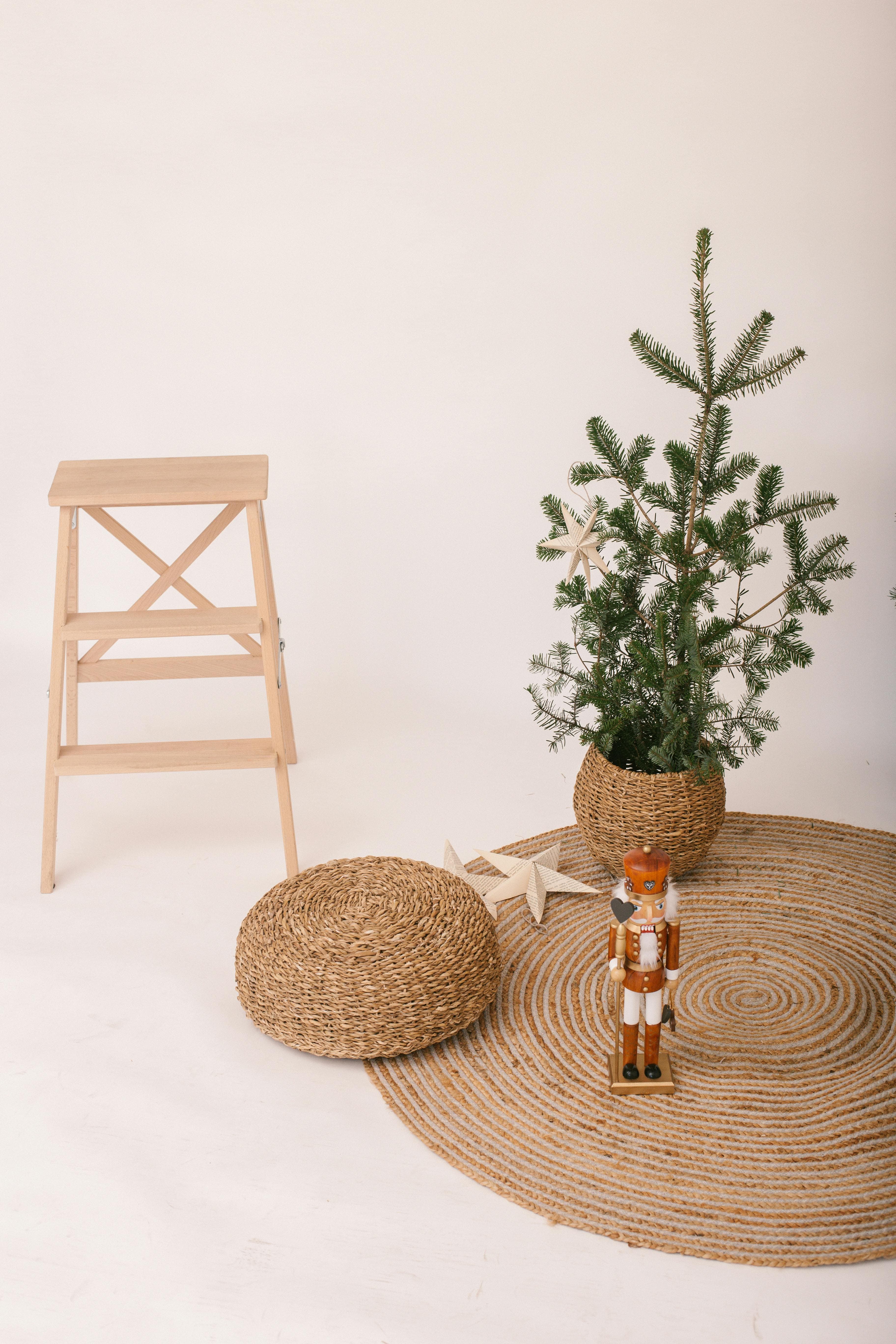 A cozy, minimalist Christmas setup featuring a nutcracker, a small tree, and woven textures in a neutral setting.