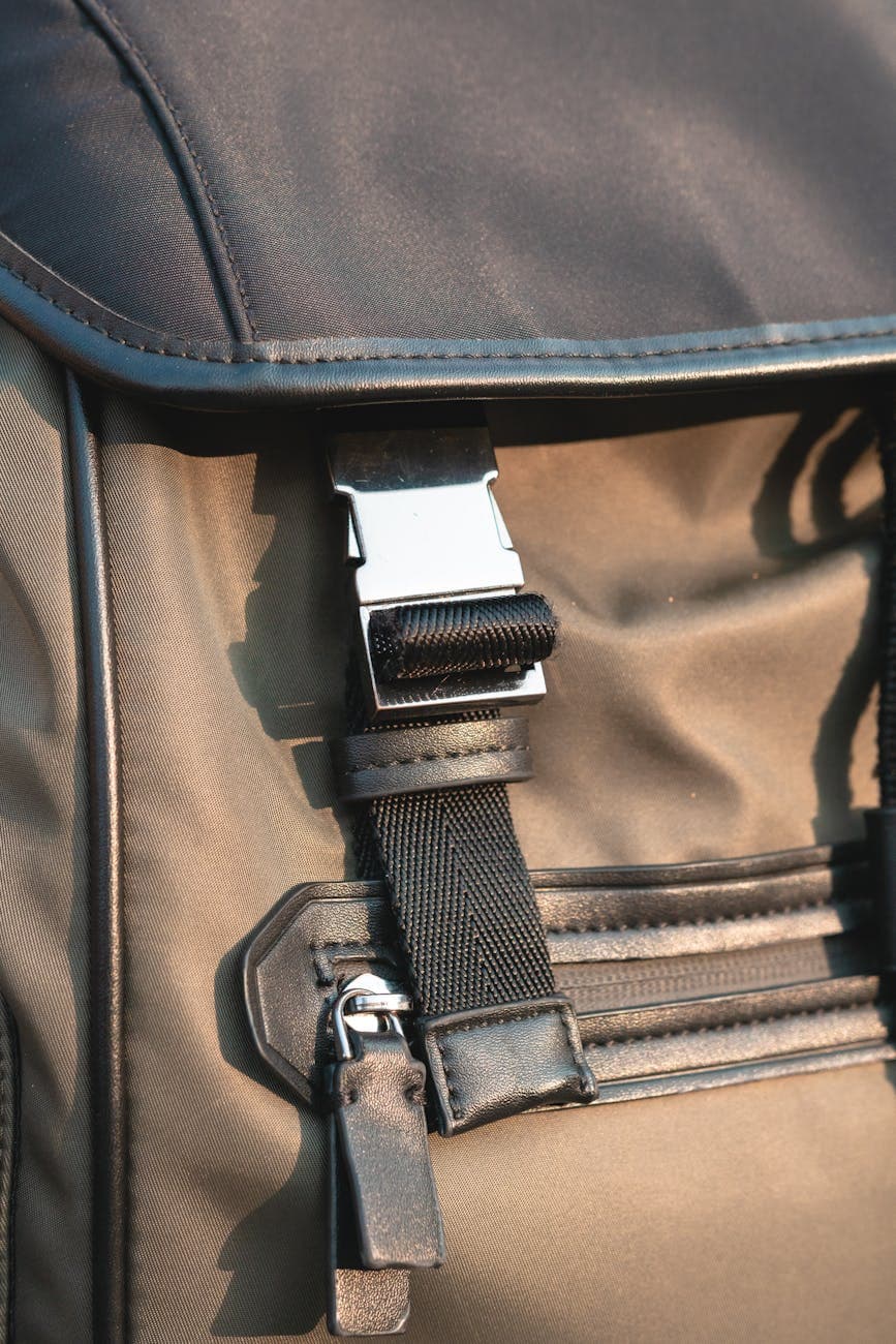 Close-up of a stylish nylon backpack featuring a metal buckle and zipper pocket detail.