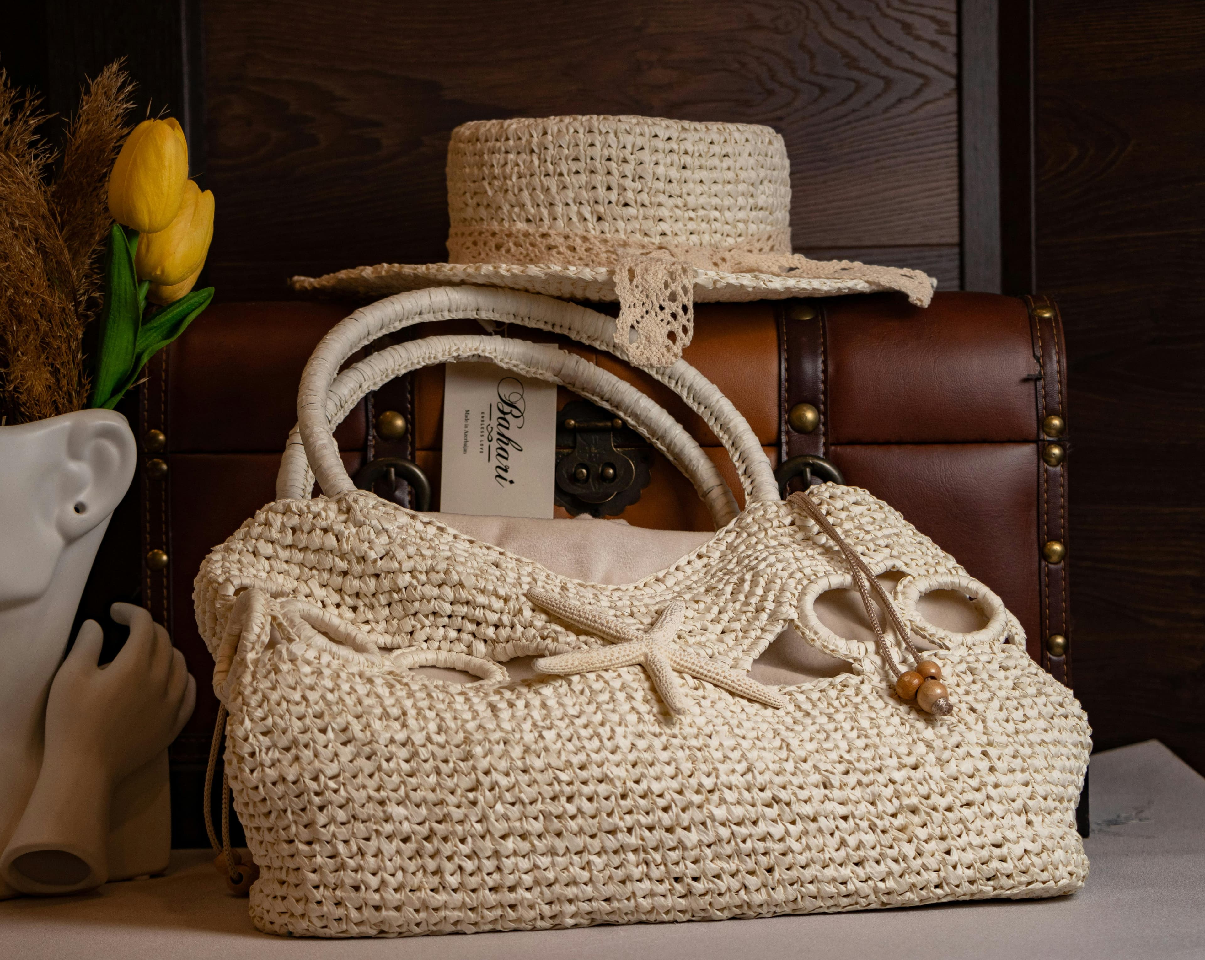Stylish straw bag and hat paired with vintage luggage for a classic rustic look.